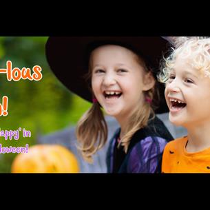 Children two children laughing. One dressed as a witch and the other wearing an orange top with a bat pattern.