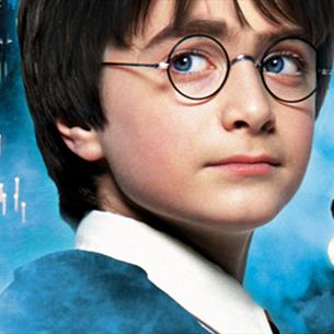 Harry Potter, Hagrid, Dumbledore and Hogwarts in the background of 'The Philosopher's Stone' movie poster.