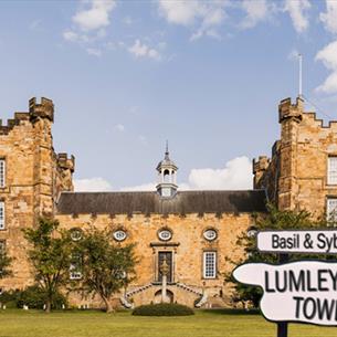 Lumley Castle Exterior and a sign which reads, 'Basil & Sybil's Lumley Towers'