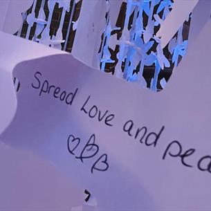 Text reads, 'Spread Love and Peace' -paper peace doves in the background. 