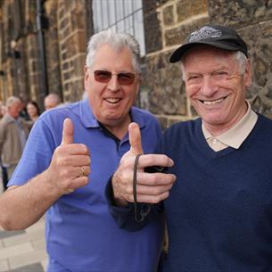 Two gentleman at Hopetown, smiling and  giving a 'thumbs up'.