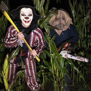 An axe wielding clown and person with a mask and chainsaw - Scare Night at Thorpe Farm Centre.