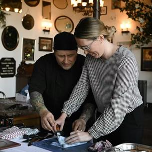 Peter Miskin showing a guest how to prepare seafood.