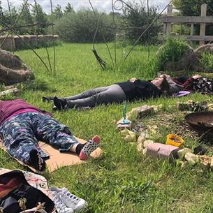 People lying in the grass at Dalton Moor Farm enjoying a Mindful Morning