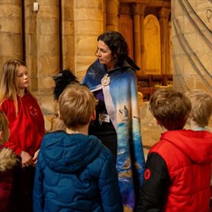 Children gather in a circle to enjoy family activities at Durham Cathedral. 
