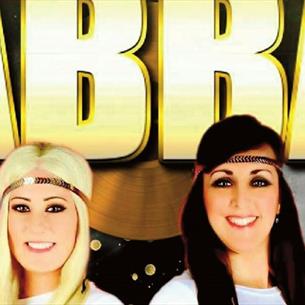 Abba Tribute 'Voulez 2' members smiling. Poster decorated with snowflakes and gold stars.