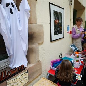 Children at a BrickLab workshop at Hopetown Darlington. A spooky ghost hangs over them on the wall.