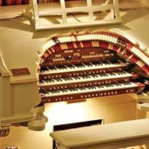The mighty wurlitzer, an ornate piano- like instrument with a burgundy curtain in the background
