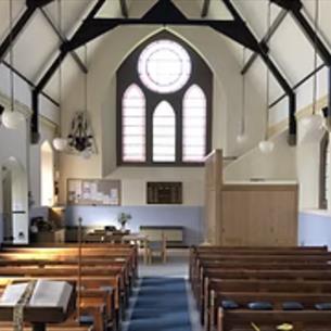 The interior of a church with pews and stained glass windows
