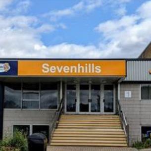 External view of a small building with a yellow sign reading Sevenhills