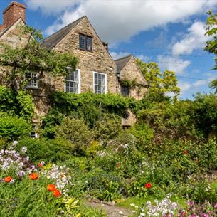 Lush greenery and gardens surrounding a stone building