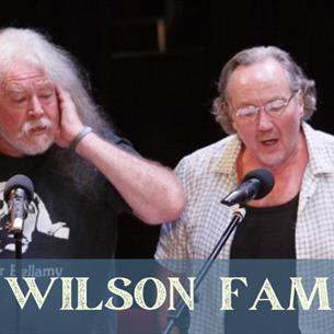 Four men singing on stage, with text underneath The Wilson Family.
