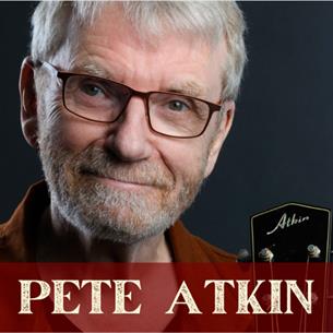 Musician Pete Atkin, smiling with his black guitar on a grey background