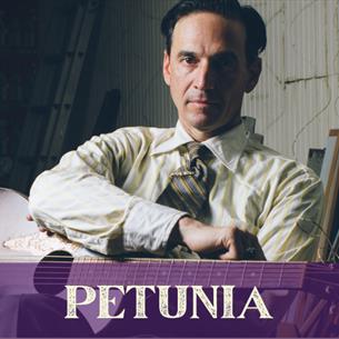 A person wearing a shirt and tie, holding a guitar. The text  underneath reads 'Petunia.'
