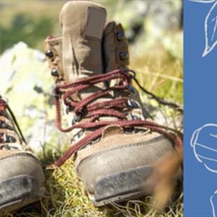 A pair of walking boots in the grass, on a blue floral background.