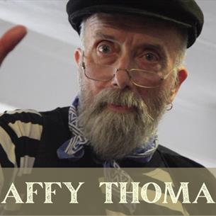 Person with glasses and a cap looking down at the camera, text 'Taffy Thomas.'
