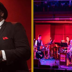A singer on stage wearing a suit and hat, accompanied by a band.