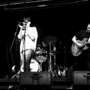 Jazz performers on stage playing their respective instruments, the image is in black and white.