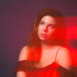 Person looking off to the left with a blurred red affect
