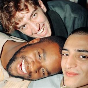Three people leaning in and smiling at the camera.