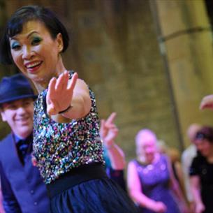 A group of people dancing in vintage clothing.
