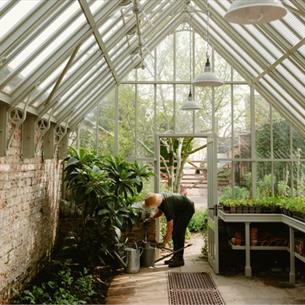 Gardening Through The Seasons with Becky Crowley – Autumn - Person tending to their green house, wearing a hat.