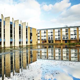 View of the exterior of Van Mildert College with lake to foreground.