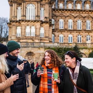 Four friends enjoying festive drinks at The Bowes Museum Winter Market. ©TheBowesMuseum