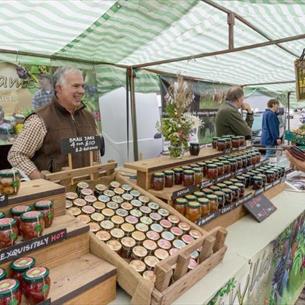 Chutney trader. Woman looking at stall and holding purse.