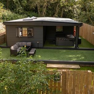 Exterior image of 'The Oak', Beamish Glamping, in a woodland location, showing the outdoor seating area.