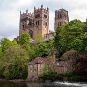 view of the west and central towers of Durham Cathedral with trees, Fulling Mill and River Wear in the foreground