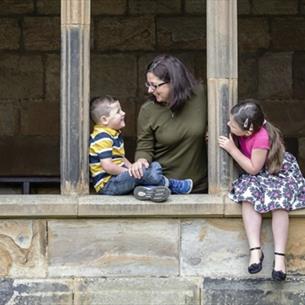 Family sat in the cloisters at Durham Cathedral Museum Family Fun Trail