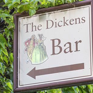 A sign saying The Dickens Bar