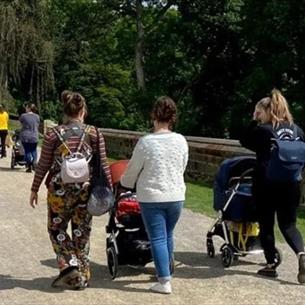 A group of women with pushchairs going for a walk in the sunshine