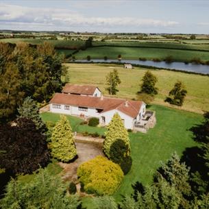 Overhead view of The Covey surrounded by tress and view of Hurworth Burn Reservoir.