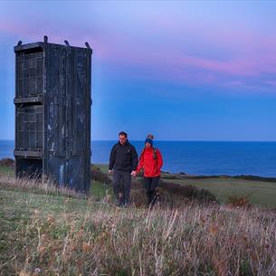 Image of a couple enjoying a walk at twilight along the Durham Heritage Coast