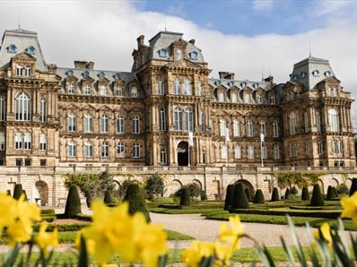 The exterior of The Bowes Museum and its grounds on a sunny day.