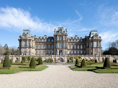 The exterior of The Bowes Museum and its grounds on a sunny day.