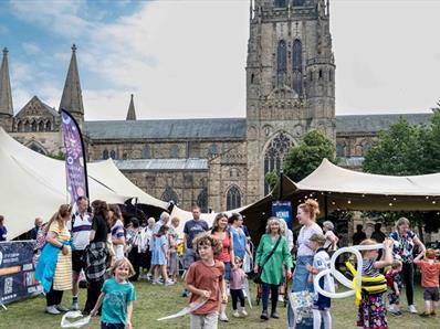 Crowds of people enjoying the Durham Fringe Festival on Palace Green, Durham City.