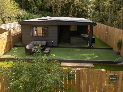 Exterior image of 'The Oak', Beamish Glamping, in a woodland location, showing the outdoor seating area.