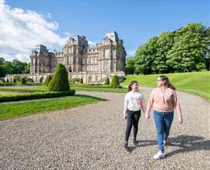 Two people walking outside of The Bowes Museum