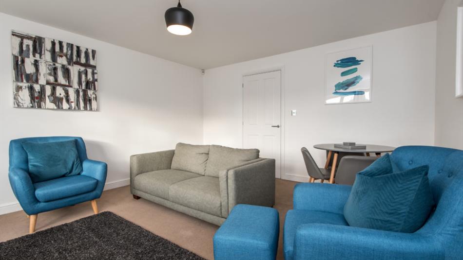 Living area with grey sofa and blue armchairs