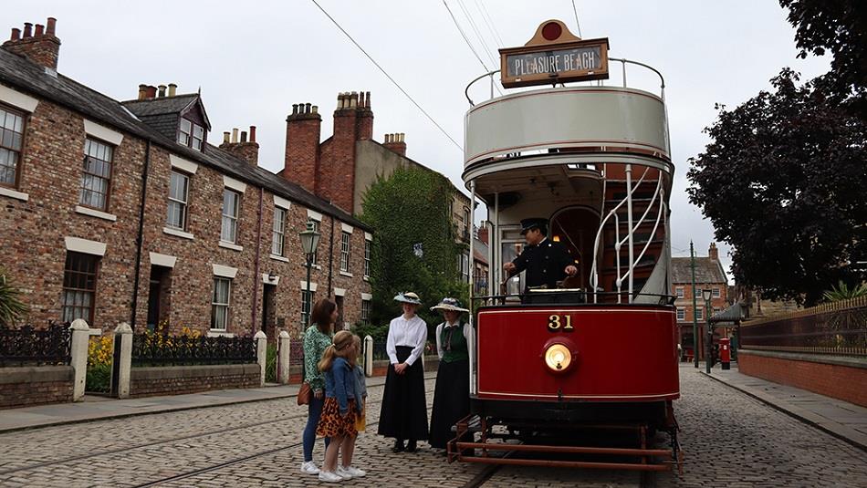 Image of the 1900s Town Street at Beamish Museum, people waiting to board the tram.