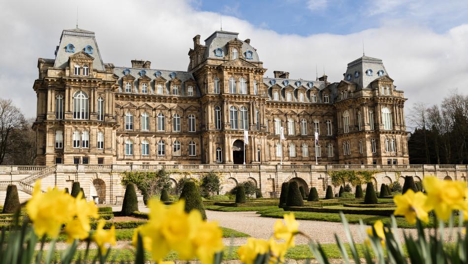 The exterior of The Bowes Museum and its grounds on a sunny day.
