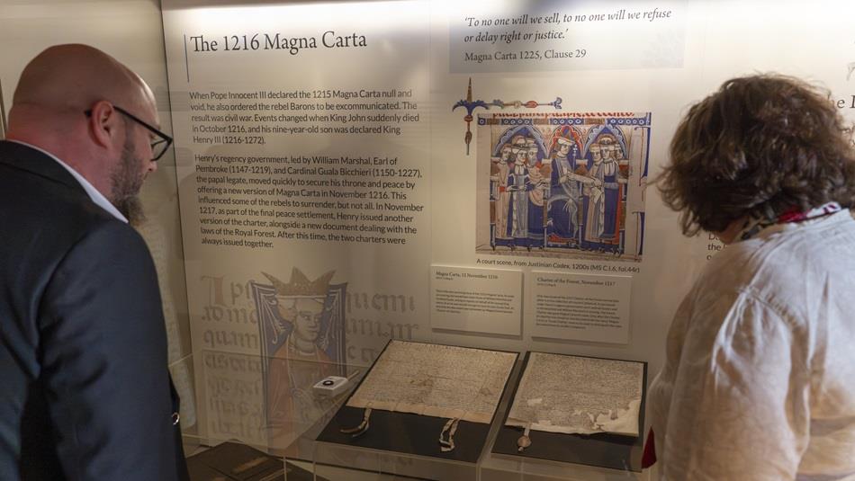 Two people looking at the 1216 Magna Carta at Durham Cathedral Museum