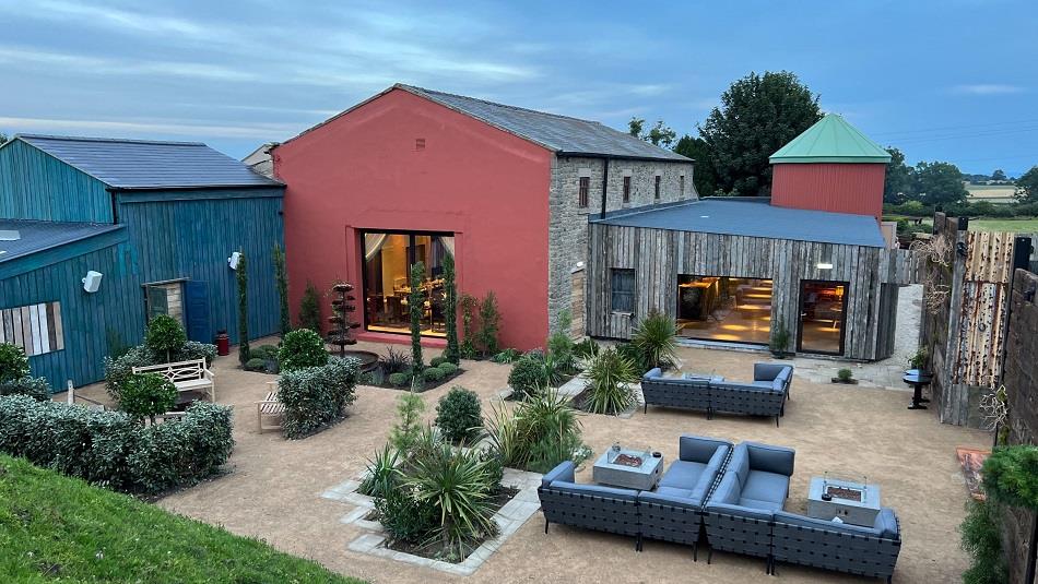 Exterior of Runa Farm with outdoor seating and shrubs