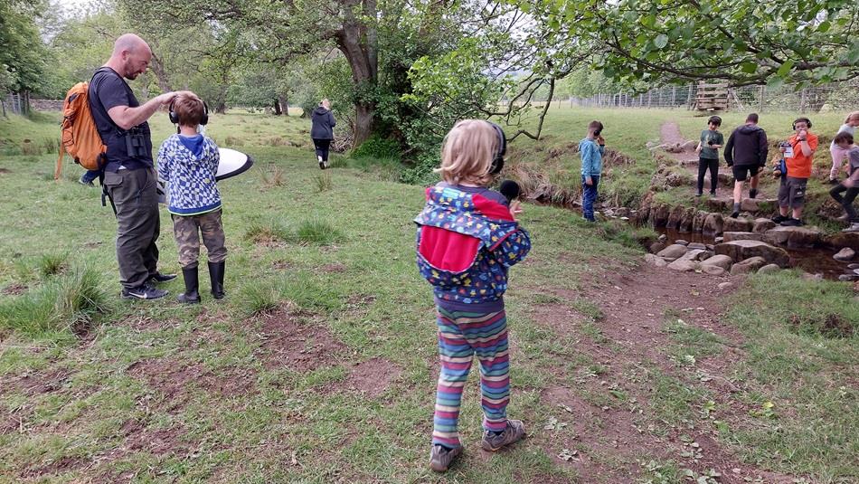 Children outdoors listening to sounds of nature