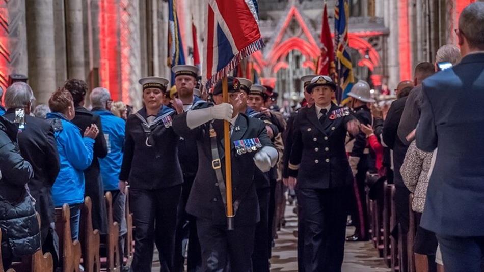Festival of Remembrance service in Durham Cathedral with members of the armed forces marching down the Nave with the Union Jack held high