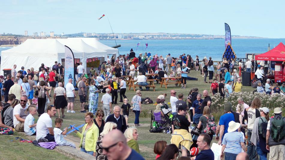 Crowds of people at Seaham Food Festival with north sea visible in the background.