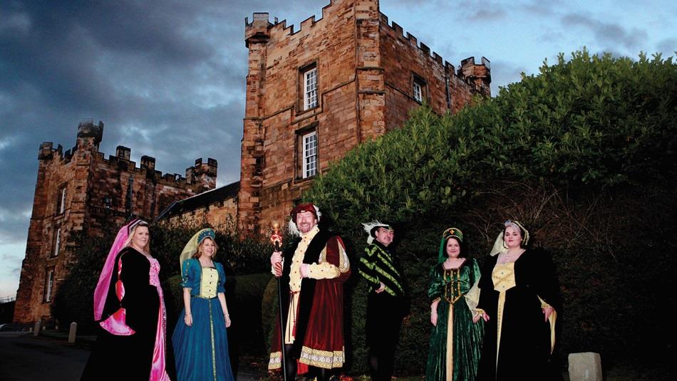 Men and women dressed in Elizabethan costume with Lumley Castle in the background